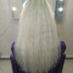 Девушка с нарощенными белыми волосами, парикмахерское кресло, зеркало с лампами